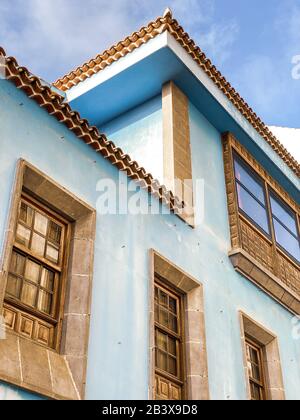 Frammento architettonico del vecchio edificio luminoso in stile coloniale con finestre e decor semplice. Immagine realizzata sul telefono cellulare Foto Stock