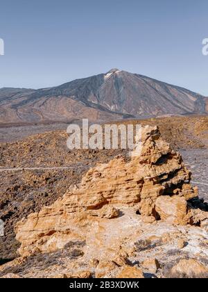 Bellissimo paesaggio roccioso sulla valle vulcanica con il vulcano Teide sullo sfondo durante una giornata di sole. Immagine realizzata sul telefono cellulare Foto Stock