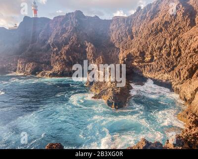 Bellissimo paesaggio su una costa rocciosa con oceano ondulato durante un tramonto. capo Teno a nord-ovest dell'isola di Tenerife. Immagine realizzata sul telefono cellulare Foto Stock