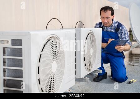 Uomo Che Esegue Il Controllo Del Riscaldamento, Della Ventilazione E Dell'Aria Condizionata Foto Stock