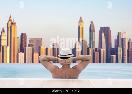Uomo Nella Piscina Infinita Con Lo Skyline Di Dubai In Background Foto Stock