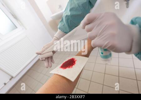 Un medico mette su un bendaggio di pressione in un ospedale Foto Stock