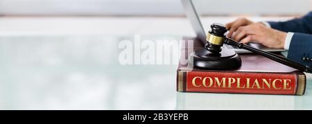 Giudicate Gavel E La Tavola Armonica Nel Compliance Law Book Foto Stock