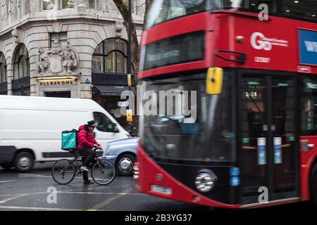 Londra, Regno Unito - 13 febbraio, 2020, autobus rosso e taxi nero su uno sfondo di un edificio grigio Foto Stock