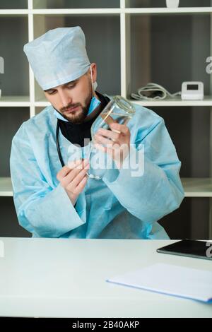 Il medico entra in una soluzione iniettabile in siringa Foto Stock