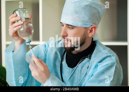 Il medico entra in una soluzione iniettabile in siringa Foto Stock