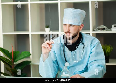 Il medico entra in una soluzione iniettabile in siringa Foto Stock