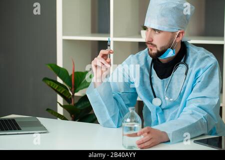 Il medico entra in una soluzione iniettabile in siringa Foto Stock