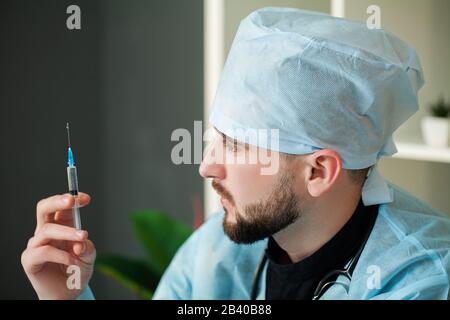 Il medico entra in una soluzione iniettabile in siringa Foto Stock