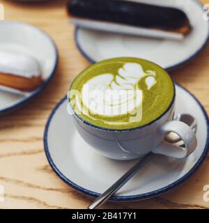 Matcha verde con un'eclair. Accogliente caffetteria. Foto Stock