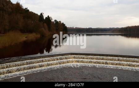 Swinsty Reservoir in Springtime che mostra l'acqua che scorre sopra lo stregone lungo lo scivolo e nel fiume Washburn verso Lindley Wood Reservoir Foto Stock