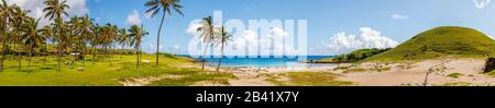 Vista panoramica della spiaggia di Anakena con palme tropicali e della sua baia sabbiosa, sulla costa settentrionale dell'isola di Pasqua (Rapa Nui), Cile Foto Stock