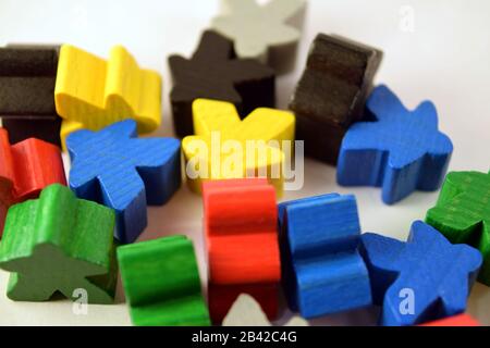 Meeples colorati su sfondo bianco. Pezzi di gioco da tavolo strategia. Concetto di gioco Euro. Foto Stock