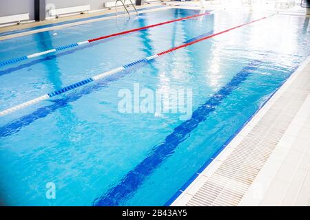 Piscina coperta, concetto sano. Piscina per competizione. Piscina con corsie per nuotare. sport e divertimento. Relax, ricreazione e sport Foto Stock