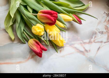 Bei tulipani per la Festa della mamma su sfondo di marmo, vista laterale.Giornata Internazionale delle Donne.bouquet di bei tulipani primaverili. Tulipano fresco e colorato Foto Stock