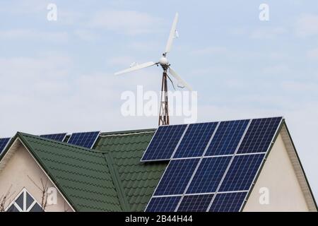 windmill e casa con pannelli solari Foto Stock