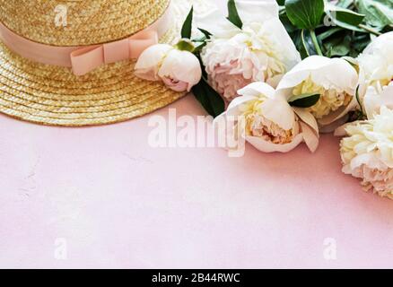 Estate vacanze sfondo. Peonie rosa e il cappello di paglia Foto Stock