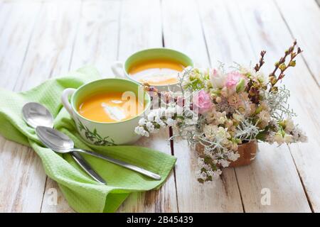 Zuppa di purea, fatta di zucca arancione, patate dolci e carote, servita con panna acida Foto Stock