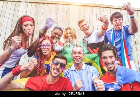 Felici tifosi di sport divertirsi durante il gioco del mondo di calcio - giovani tifosi allo stadio prima di partita di calcio con Air Horn, bandiere e megafono - Friendsh Foto Stock