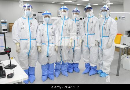 (200306) -- WUHAN, 6 marzo 2020 (Xinhua) -- i membri Del Personale posano per una foto di gruppo al laboratorio clinico dell'ospedale Leishenshan (Thunder God Mountain) a Wuhan, nella provincia centrale cinese di Hubei, 4 marzo 2020. Il laboratorio ha riunito personale medico di diversi ospedali e istituti di analisi medica, la maggior parte dei quali è femminile. Il loro lavoro consiste nel testare i campioni prelevati dai pazienti COVID-19 e fornire informazioni diagnostiche ai medici. Anche se non vengono a contatto diretto con i pazienti, devono comunque indossare strati di tute protettive per il contatto diretto con l'vir Foto Stock