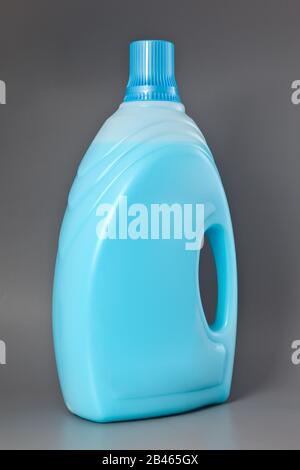 Flacone di plastica detergente trasparente con liquido blu isolato su grigio. Foto Stock