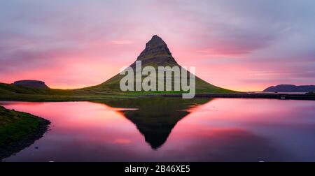 Pittoresco paesaggio panoramico con la montagna di Kirkjufell, il lago limpido e il paesaggio notturno nel cielo del tramonto Foto Stock