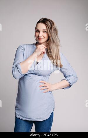 Ritratto di bell'uomo in grrey e vestito blu ufficio guarda in lontananza e sorride Foto Stock