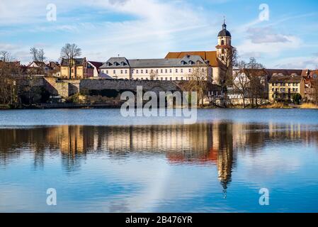 Vista panoramica delle case su un lago con le mura della città sullo sfondo Foto Stock