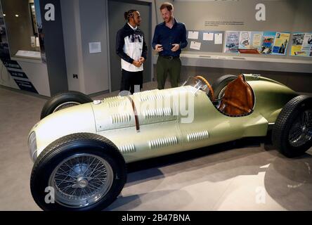 Il Duca del Sussex parla con il campione del mondo di Formula Uno Lewis Hamilton durante una visita al circuito di Silverstone nel Northamptonshire per aprire ufficialmente l'Esperienza di Silverstone, un nuovo museo immersivo che racconta la storia del passato, del presente e del futuro delle corse automobilistiche britanniche. Foto Stock