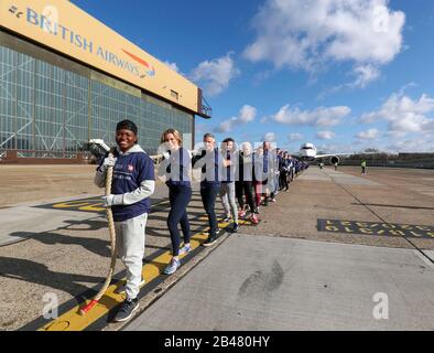 (Da davanti a dietro) Nicola Adams, Gabby Logan, Garry Lineker, Joe Wicks, Iwan Thomas e Alfie Hewett si uniscono ai membri del personale nel tentativo di rompere il Guinness World Record per il più pesante 100m A350 aereo tira durante un evento di soccorso sportivo all'aeroporto di Heathrow a Londra. Foto Stock