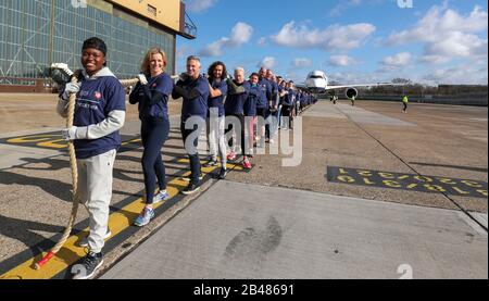 (Da davanti a dietro) Nicola Adams, Gabby Logan, Gary Lineker, Joe Wicks, Iwan Thomas e Alfie Hewett si uniscono ai membri del personale nel tentativo di rompere il Guinness World Record per il più pesante tiro in aereo 100m A350 durante un evento di Sport Relief all'aeroporto di Heathrow a Londra. Foto Stock