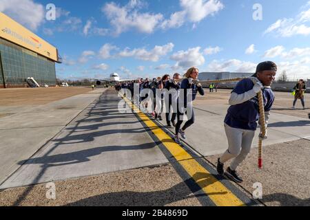 (Da davanti a dietro) Nicola Adams, Gabby Logan, Gary Lineker, Joe Wicks, Iwan Thomas e Alfie Hewett si uniscono ai membri del personale nel tentativo di rompere il Guinness World Record per il più pesante tiro in aereo 100m A350 durante un evento di Sport Relief all'aeroporto di Heathrow a Londra. Foto Stock