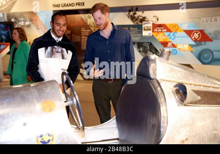 Il Duca del Sussex parla con il campione del mondo di Formula Uno Lewis Hamilton durante una visita al circuito di Silverstone nel Northamptonshire per aprire ufficialmente l'Esperienza di Silverstone, un nuovo museo immersivo che racconta la storia del passato, del presente e del futuro delle corse automobilistiche britanniche. Foto Stock