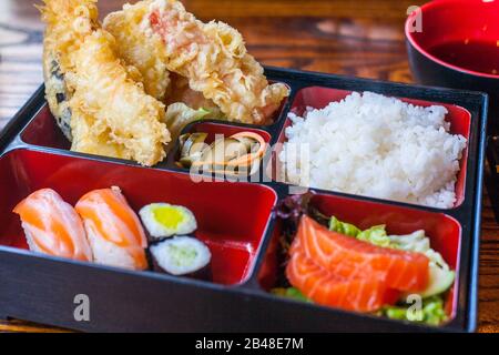 Sushi bento box con gamberi tempura, riso, salmone e sushi Foto Stock