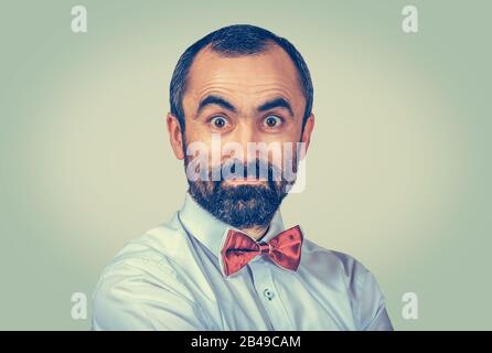Uomo maturo scioccato che guarda perplesso a te, telecamera insoddisfatti. Ritratto di closeup di razza mista modello barbuto latino americano ragazzo isolato su verde chiaro YE Foto Stock