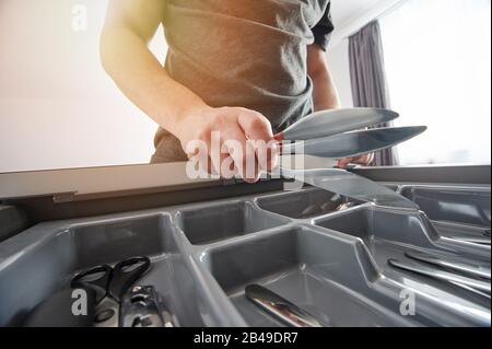 Cucina coltelli in mano primo piano vista su sfondo appartamento Foto Stock