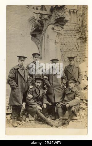 Cartolina originale dell'era WW1 di lavoratori degli uffici postali di Brighton, 28th Division Signal Company, in piedi accanto alle rovine della Cattedrale di Ypres, datata al retro e' aprile 1915. Fotografato forse poco prima della terribile seconda battaglia di Ypres, nelle Fiandre occidentali, in Belgio. La seconda battaglia di Ypres fu notevole per il primo uso su larga scala di gas velenosi da parte dei tedeschi. Foto toccante. Quanti di questi uomini sono sopravvissuti alla prima guerra mondiale? Soldati della prima guerra mondiale soldati della prima guerra mondiale. Foto Stock