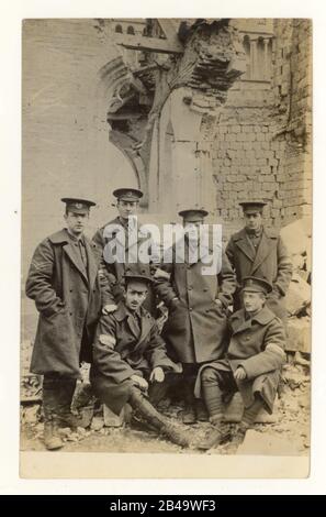 WW1 era cartolina di lavoratori di ufficio postale da Brighton, 28th Division Signal Company, in piedi accanto alle rovine della cattedrale di Ypres, datata al contrario di aprile 1915, 2nd battaglia Ypres, Fiandre occidentali, Belgio Foto Stock