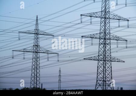 costruzione di piloni elettrici con confusione di cablaggio in cielo blu Foto Stock