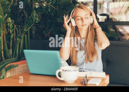 la ragazza ascolta la musica del laptop delle cuffie Foto Stock