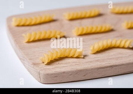 Tipi di pasta girandole in legno. Vicino a noodles italiani Foto Stock