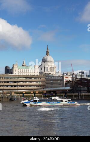 Una barca sul fiume Tamigi London UK passa di fronte alla Cattedrale di St Pauls - vista attraverso il Tamigi da South Bank, Londra UK Foto Stock