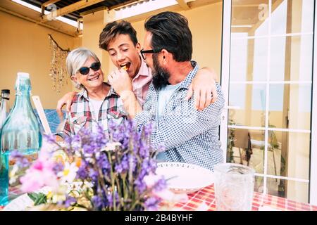 Tre generazioni diverse famiglia caucasica persone ocncept mangiare insieme pranzo - nonna, figlio e nipote hanno fon con amore e amicizia all'aperto a casa Foto Stock