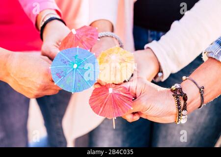 Primo piano con un gruppo di persone che sostengono e che mostra quattro cocktail ombrelloni insieme - di amicizia e cooperazione del team festeggia concetto lifestyle Foto Stock