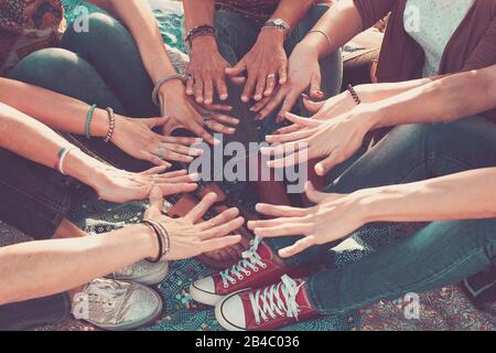 team e concetto di amicizia con la folla di mani e piedi tutti insieme toccare e cooperare - persone caucasiche amici godendo l'attività di svago all'aperto - amore hippy Foto Stock