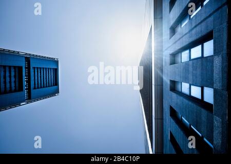 Blu toni freddi colori di grattacieli con luce solare - guardando in alto prospettiva, vista della città di uffici e quartiere finanziario con banca e assicurazione persone al lavoro Foto Stock