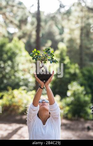 Concetto di persone dicono di no alla deforestazione e salvare il pianeta e gli alberi - rispetto per la natura e cura del nostro futuro - giornata della terra con piccolo albero nella foresta - ambiente all'aperto Foto Stock