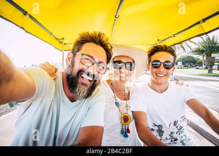 Concetto di famiglia di gente felice - figlio di madre e padre ridere molto e divertirsi insieme nell'attività di svago all'aperto - gruppo caucasico di amici di età e generazioni diverse Foto Stock