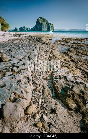 Costa rocciosa di linea principale alla splendida isola Pinagbuyutan in background. Paesaggio onirico scenario in El Nido, PALAWAN FILIPPINE. Foto Stock