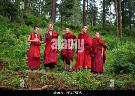 Happy Monks jumping Gangtey Dzong monastero villaggio Gangten Phobjikha Valle Bhutan. Il Monastero di Gangteng, conosciuto generalmente come Gangtey Gonpa o Gangte Foto Stock